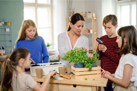 Mutter und Kinder beim Pflanzen